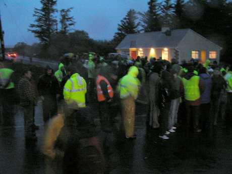 People gather in the dawn rain at Bellanaboy Bridge