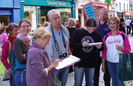 Italians from Umbria signing the petition with Andy holding placard.
