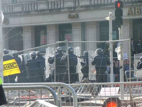 Riot Police Advance Through the Building Site